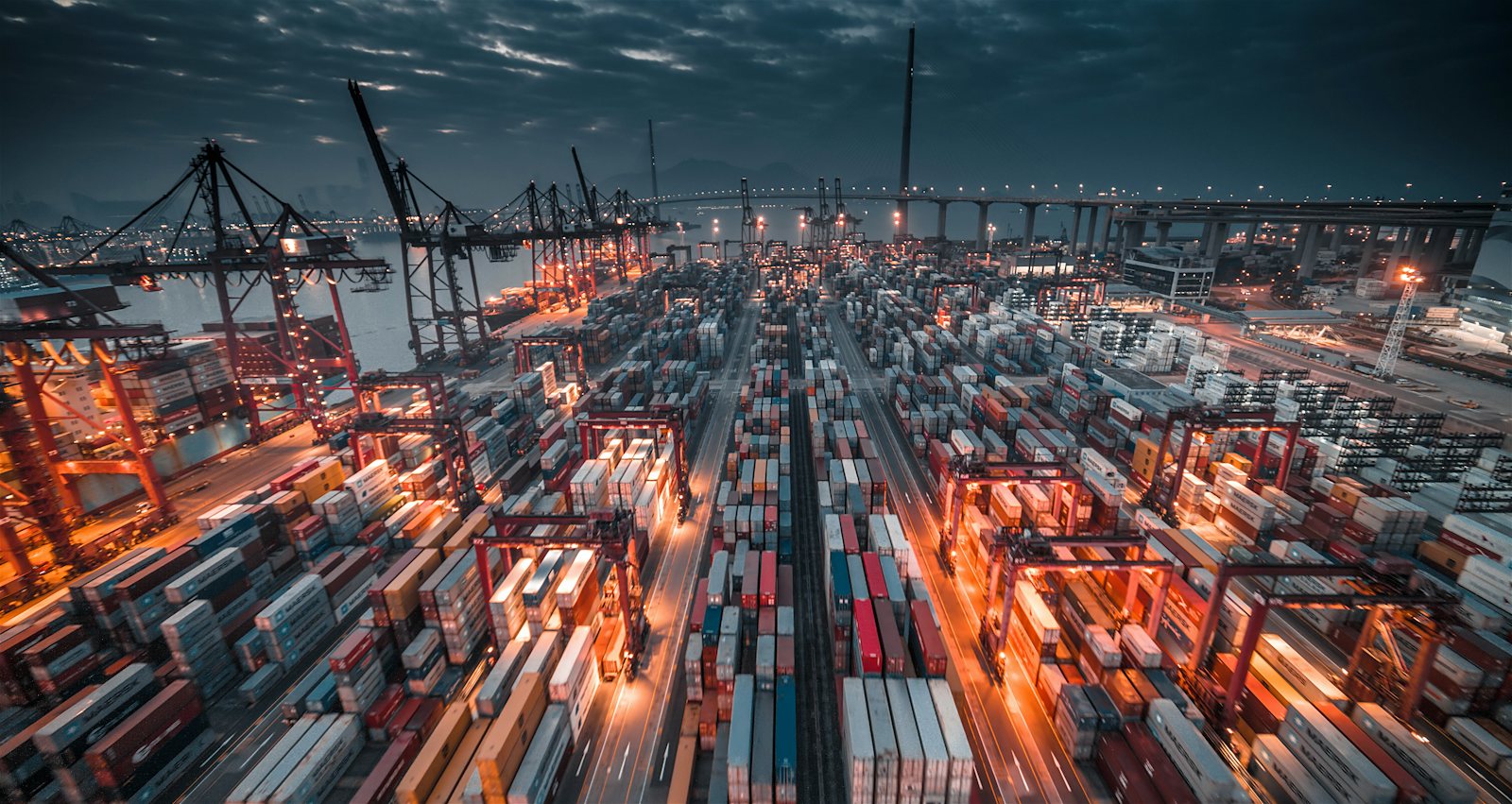 Container port with cranes lit at night